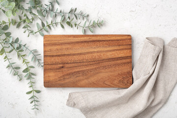 Wood cutting board with linen napkin and plant