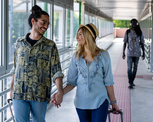 happy couple leaving for their trip, husband and wife head to the boarding gate to take the airplane