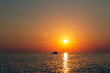 Naklejka na ściany i meble Silhouette of small yacht, ship floating on sea at sunset. Istria, Croatia
