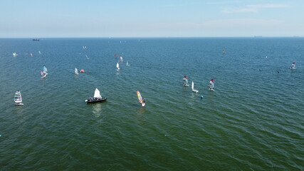 Naklejka premium Aerial view of group of windsurfers and sailors training on Baltic Sea