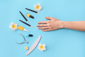Female hand and professional tools for manicure on color background