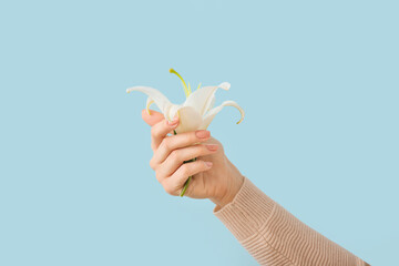 Woman with beautiful manicure holding flower on color background