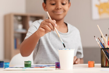 Little African-American boy painting at home