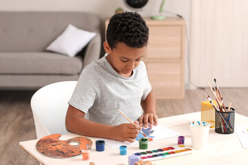 Little African-American boy painting at home
