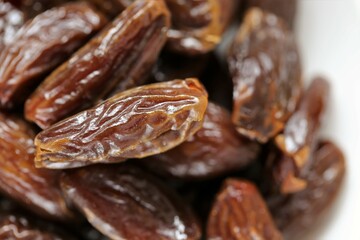Dry dates close-up in a white plate . dates pile. Sweet fruit healthy dessert. High quality photo
