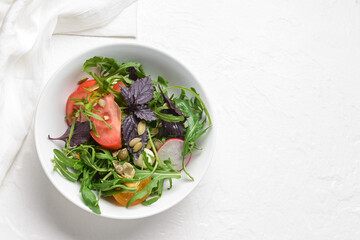 Bowl with tasty fresh salad on light background