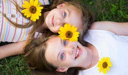 Two children lie on the grass. Smiling portrait