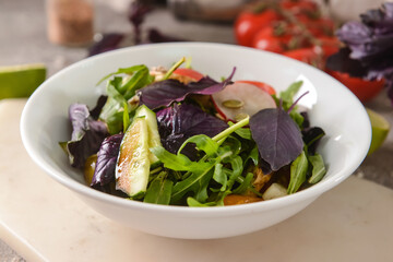 Bowl with tasty fresh salad on table, closeup