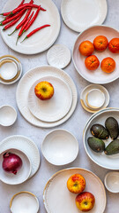 Table Setting of white ceramics with vegetables and fruit © Hein van Tonder