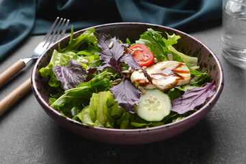 Plate with tasty fresh salad on dark background, closeup