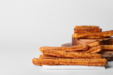 Boards with tasty churros on white background