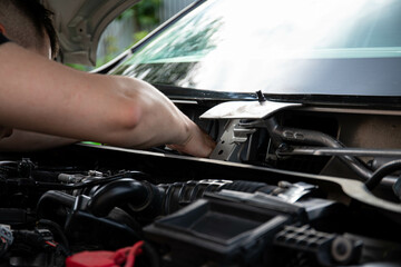 a man repairs a car. a man in blue special clothes to repair the car. engine parts machine repair maintenance breakage problem hands people man master