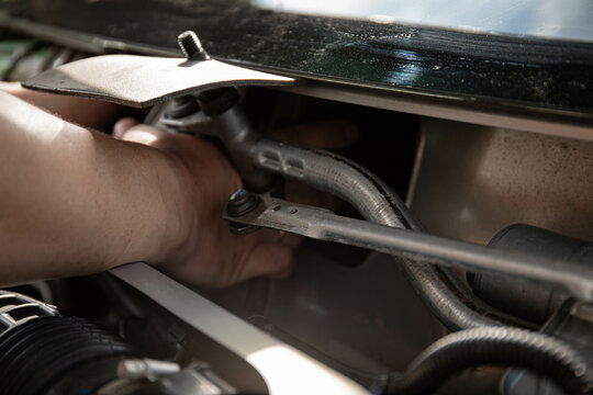 a man repairs a car. a man in blue special clothes to repair the car. engine parts machine repair maintenance breakage problem hands people man master