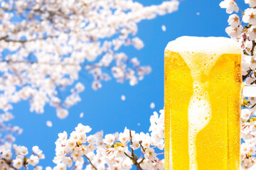 Image of a mug of beer with a background of cherry blossoms and blue sky with dripping foam and...