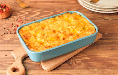 Casserole with mashed potatoes and spices on wooden background