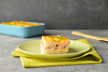 Plate with piece of mashed potato casserole on table, closeup