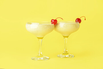 Glasses of tasty banana daiquiri cocktail on color background