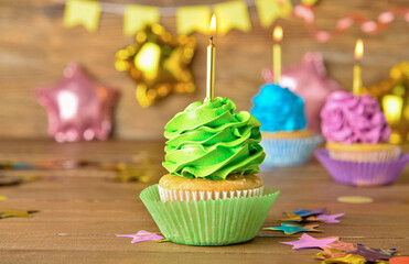 Tasty Birthday cupcakes with burning candles on wooden background