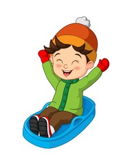 Cute little boy sledding down a hill