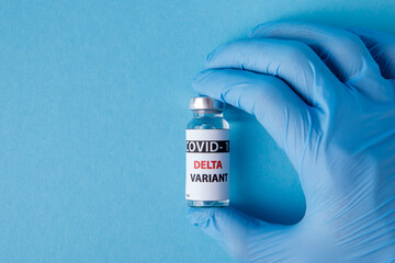 Female doctor holding syringe and COVID-19 delta variant vaccine