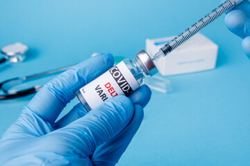 Female doctor holding syringe and COVID-19 delta variant vaccine
