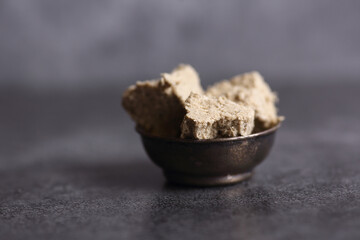 metal bowl of halva isolated on gray background
