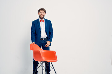 bearded man in suit sitting on red chair posing Professional