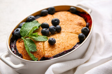 Baking dish with blueberry cobbler on table, closeup