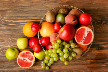 Naklejka na ściany i meble Basket with fresh fruits on wooden background
