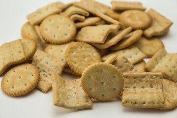 close-up of salty square and round shaped cookies on white background