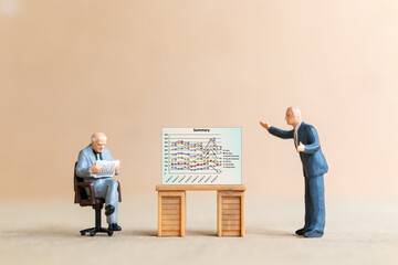 Miniature People Business people looking at analyst graph on screen background