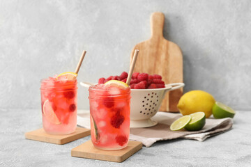Glasses of tasty raspberry lemonade on table