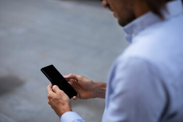Close up of businessman using the phone. Young manager typing a message