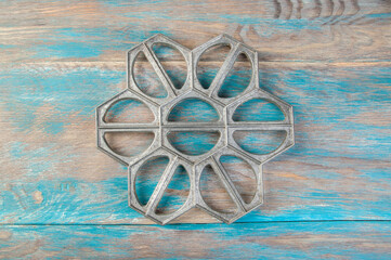 Old aluminum dumplings mold on blue wooden background.