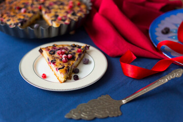 Homemade berry pie with red currant, blueberry, cherry and ricotta cheese on dark blue and red...