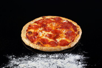 Pizza with mushrooms, sausage and olives on a wooden background
