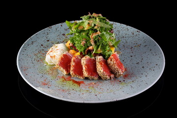 Tuna salad with poached egg on black background