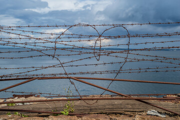 The heart shape in rusty barbed wire. Detail of Patarei prison abandoned soviet prison in Tallinn,...