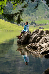 Endschleunigen am Bergsee, Frau genießt Ruhe und Stille am Alpsee.