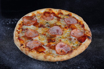 Pizza with mushrooms, sausage and olives on a wooden background