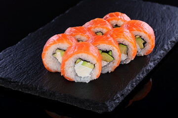 Rolls with red caviar on a black background