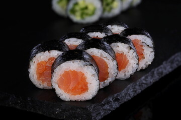 Rolls with red caviar on a black background