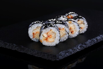 Rolls with red caviar on a black background