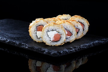 Rolls with red caviar on a black background