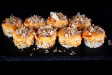 Rolls with red caviar on a black background