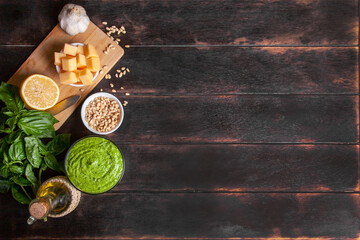 Pesto sauce in a glass bowl and ingredients for making basil sauce at home