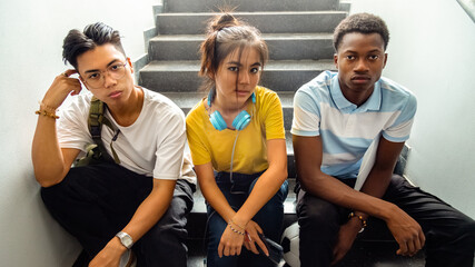 Fototapeta na wymiar Portrait of multiracial group of teen high school students sitting on stairs looking at camera. Horizontal banner image.