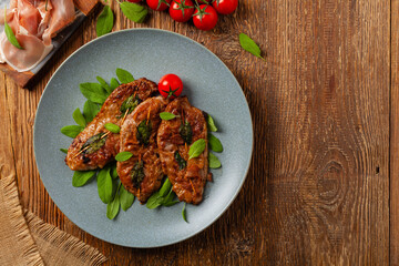 Saltimbocca. Veal schnitzel with sage and Parma ham. Italian specialty. Top view.