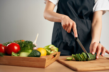 Woman in black apron slicing vegetables kitchen cooking food