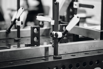 Manual welding table, clamps for holding metal components stationary.